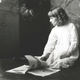 A young American kid, K D Farrer, sitting on the floor reading a picture book